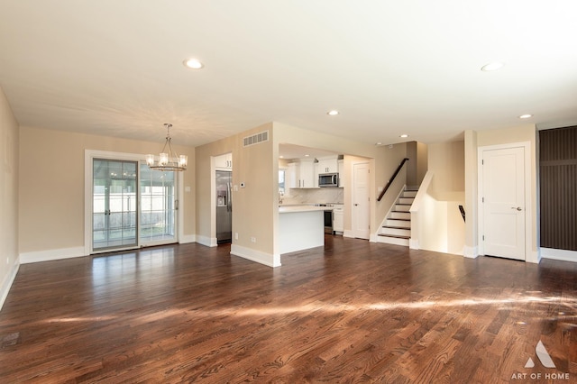 unfurnished living room featuring dark hardwood / wood-style flooring and a chandelier