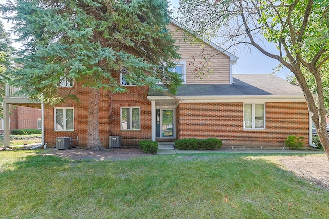 view of front of home featuring central air condition unit and a front yard