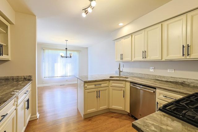 kitchen with sink, stainless steel dishwasher, kitchen peninsula, cream cabinets, and a chandelier