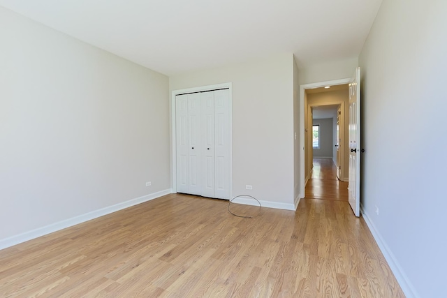 unfurnished bedroom featuring light wood-type flooring and a closet