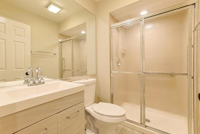 bathroom with vanity, toilet, and a shower with shower door