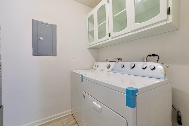 laundry room with cabinets, washing machine and dryer, electric panel, and light tile patterned flooring