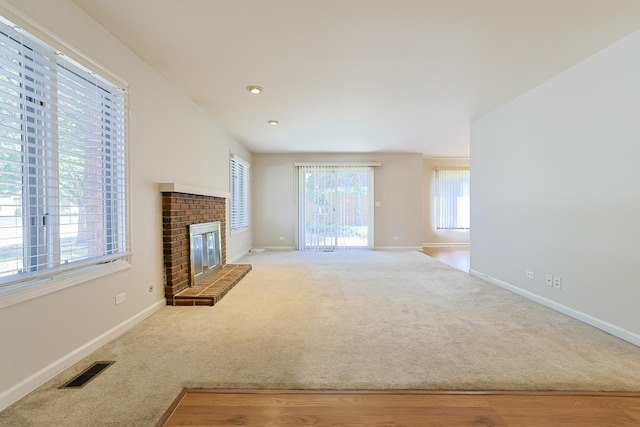 unfurnished living room with carpet and a fireplace