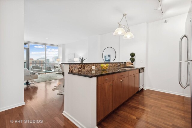 kitchen featuring stainless steel appliances, dark stone countertops, backsplash, and hardwood / wood-style floors