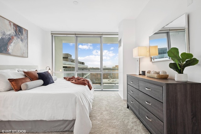 bedroom with floor to ceiling windows, light colored carpet, multiple windows, and access to exterior