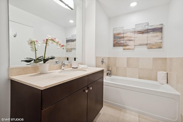 bathroom with tile patterned flooring, a washtub, and vanity