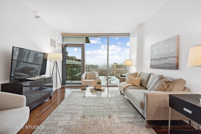 living room featuring dark wood-type flooring and floor to ceiling windows