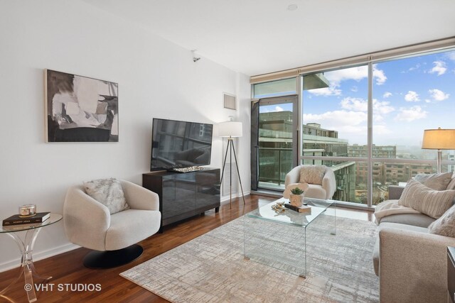 living room with floor to ceiling windows, hardwood / wood-style floors, and a healthy amount of sunlight