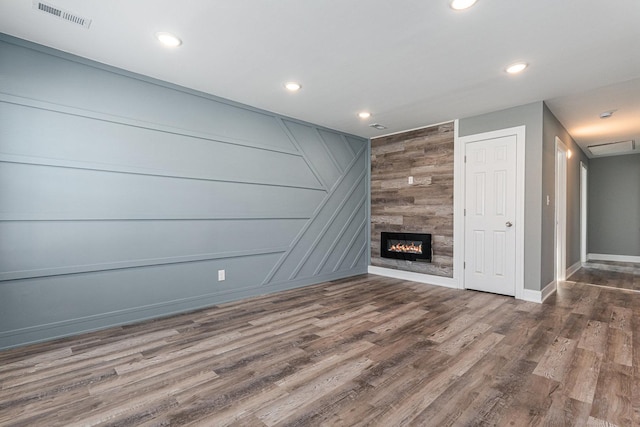 unfurnished living room with a tile fireplace and dark hardwood / wood-style floors