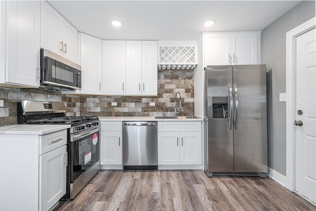 kitchen with white cabinets, appliances with stainless steel finishes, tasteful backsplash, and sink