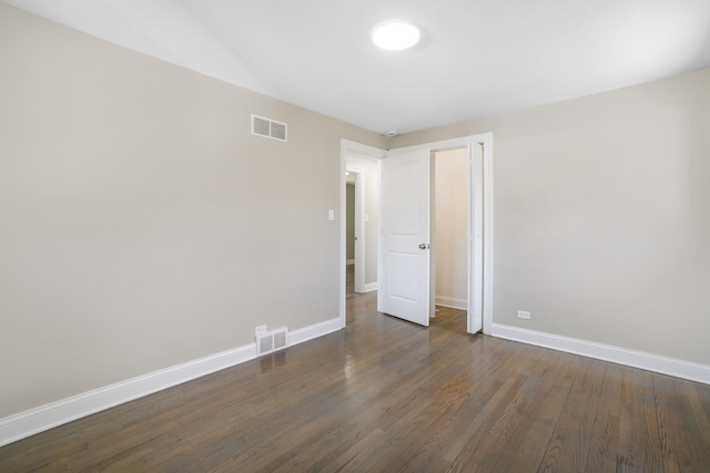 unfurnished room with dark hardwood / wood-style flooring