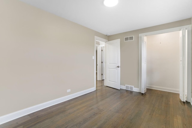 unfurnished bedroom featuring a closet and dark hardwood / wood-style flooring