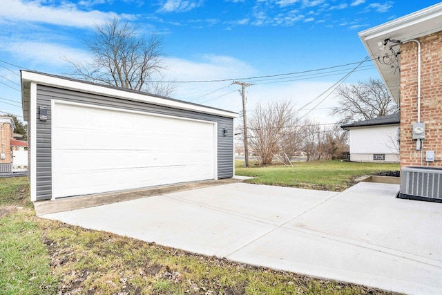 garage with central air condition unit and a yard