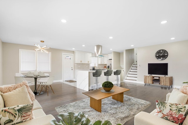 living room with sink, an inviting chandelier, and dark hardwood / wood-style floors