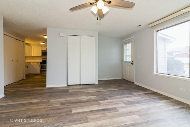 unfurnished bedroom with ceiling fan and light wood-type flooring