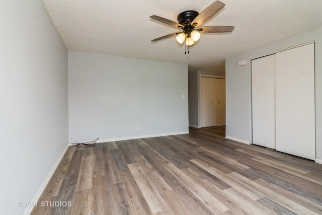 unfurnished bedroom with hardwood / wood-style floors, ceiling fan, a textured ceiling, and a closet