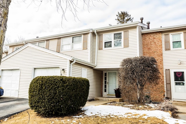 multi unit property featuring driveway and an attached garage