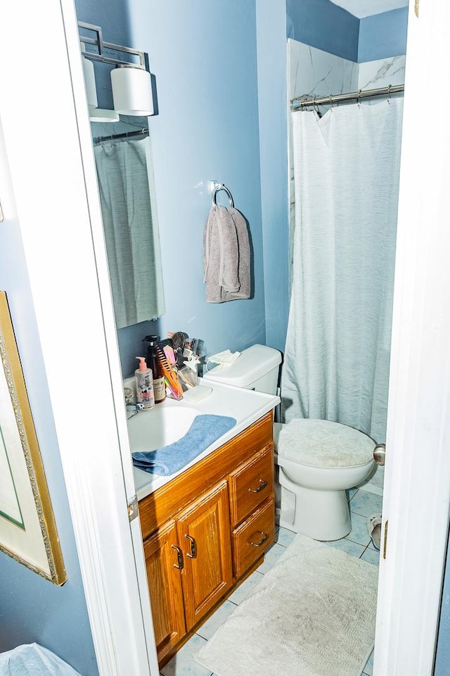 full bathroom featuring toilet, tile patterned flooring, and vanity