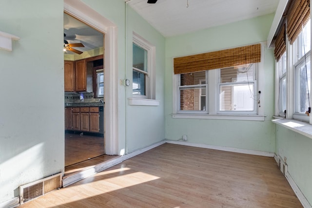 unfurnished sunroom featuring ceiling fan