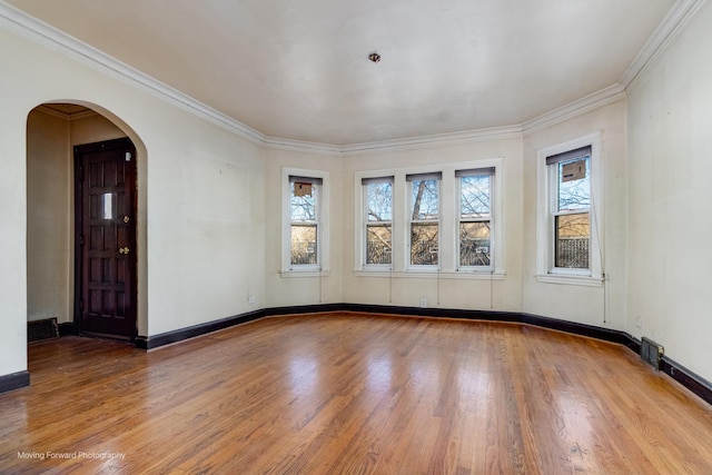 empty room with crown molding and wood-type flooring