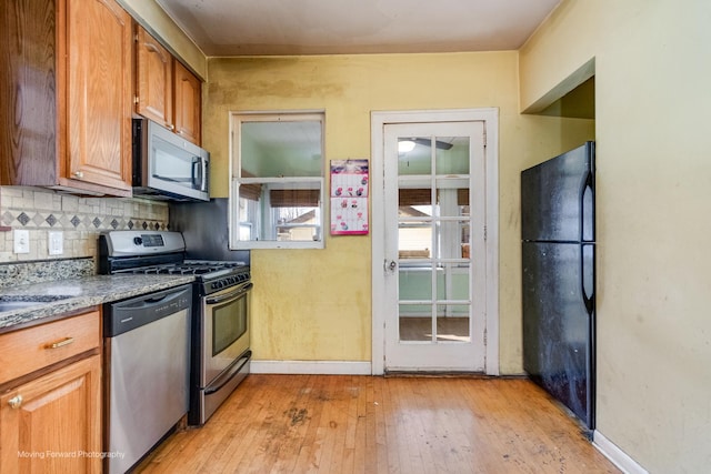 kitchen featuring backsplash, light hardwood / wood-style flooring, and stainless steel appliances