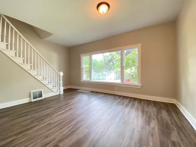 unfurnished living room with dark wood-type flooring