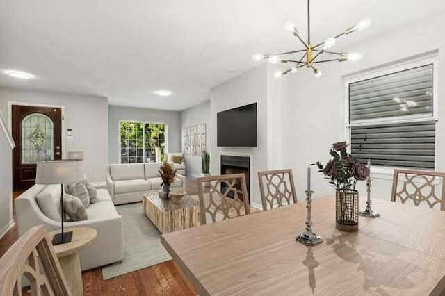 dining area featuring wood-type flooring and an inviting chandelier