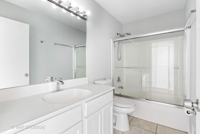 full bathroom featuring tile patterned flooring, vanity, toilet, and enclosed tub / shower combo