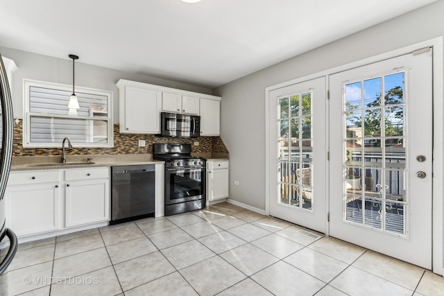 kitchen featuring decorative backsplash, appliances with stainless steel finishes, sink, white cabinetry, and hanging light fixtures