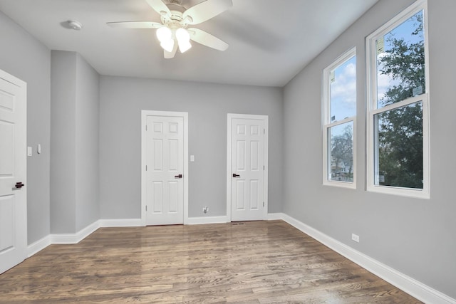 unfurnished bedroom featuring ceiling fan and dark hardwood / wood-style floors