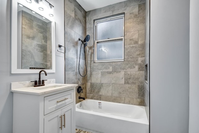 bathroom featuring tiled shower / bath combo and vanity