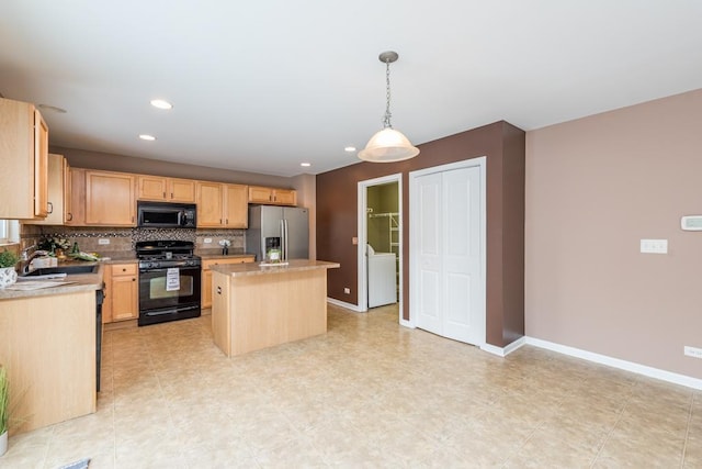 kitchen with pendant lighting, backsplash, black appliances, a kitchen island, and washer / dryer