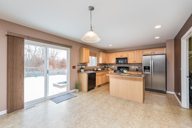 kitchen with light brown cabinets, backsplash, black appliances, hanging light fixtures, and a kitchen island