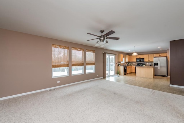 unfurnished living room featuring ceiling fan and a wealth of natural light