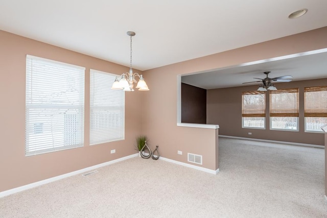 spare room featuring light carpet and ceiling fan with notable chandelier