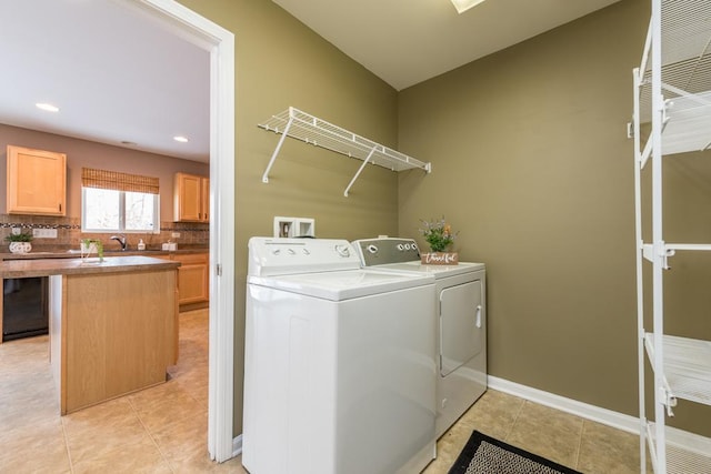 clothes washing area with separate washer and dryer, sink, and light tile patterned floors