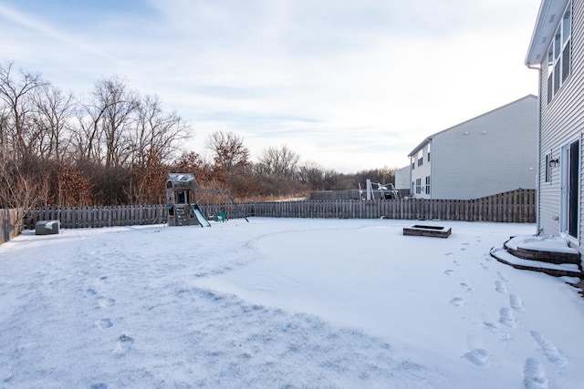 yard layered in snow with a playground