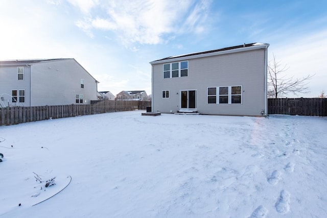 view of snow covered back of property