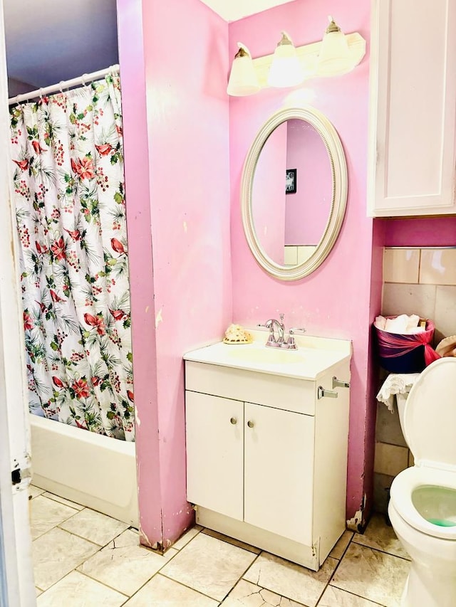 full bathroom featuring tile patterned floors, vanity, toilet, and shower / bath combo with shower curtain