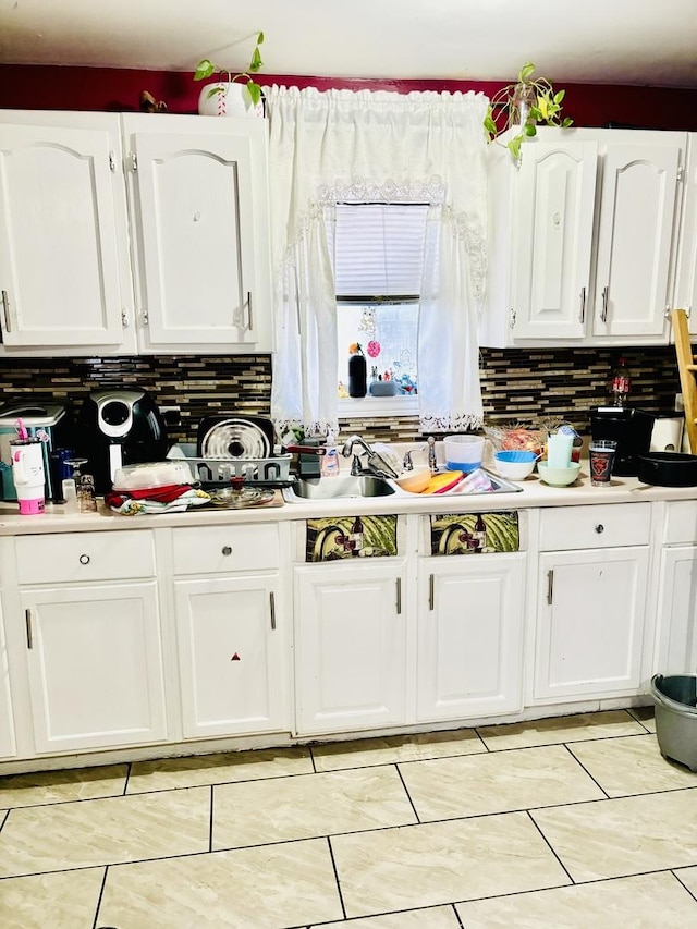 kitchen with backsplash, white cabinetry, and light tile patterned flooring