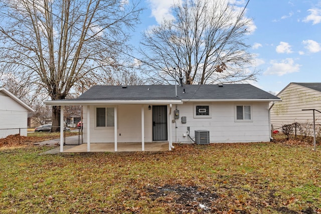 rear view of property with a yard, central AC unit, and a patio area