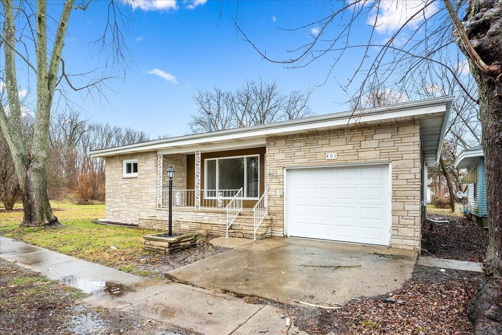 ranch-style home with a porch and a garage