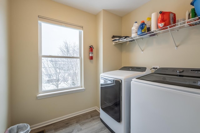 washroom with washer and dryer, light wood-type flooring, and plenty of natural light