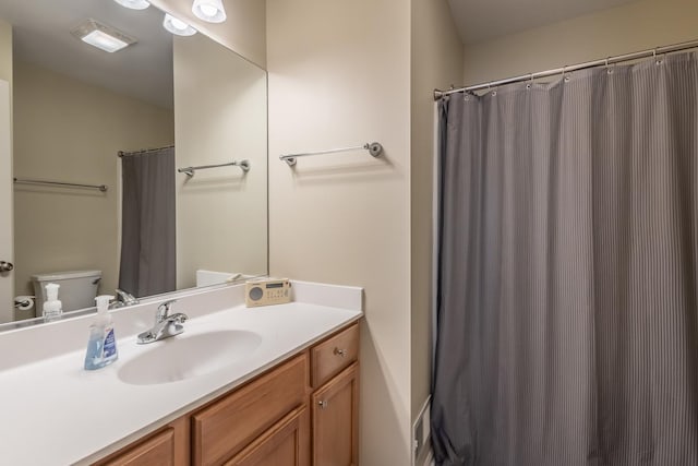 bathroom featuring curtained shower, vanity, and toilet