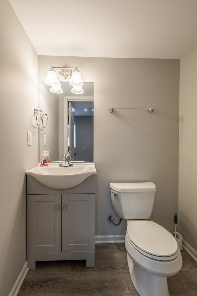 bathroom with toilet, wood-type flooring, and vanity