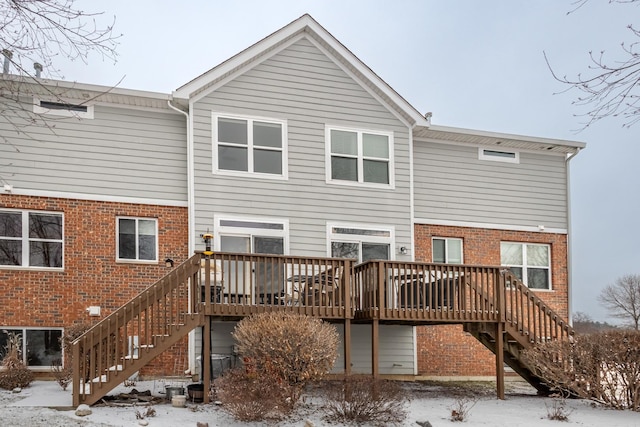 snow covered house featuring a deck