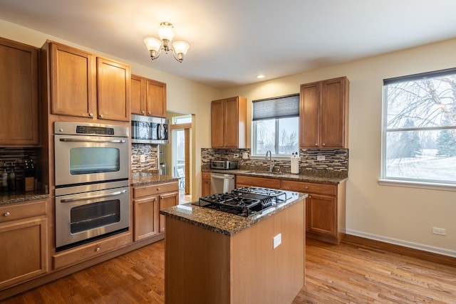 kitchen featuring sink, a kitchen island, a healthy amount of sunlight, and appliances with stainless steel finishes