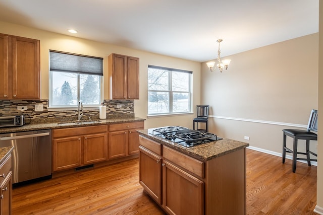 kitchen featuring sink, stainless steel appliances, a notable chandelier, and plenty of natural light