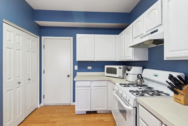 kitchen featuring white cabinets, light hardwood / wood-style floors, and white appliances