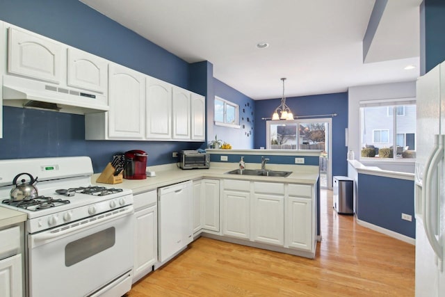 kitchen featuring pendant lighting, white appliances, white cabinetry, and sink